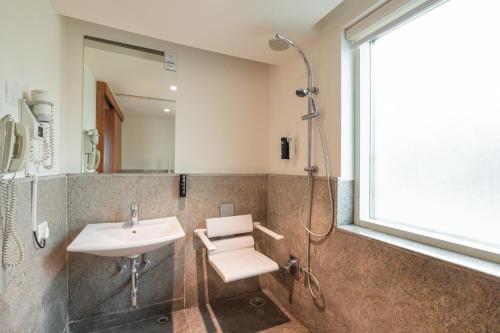 a bathroom with a sink and a shower at ibis Mumbai Airport - An Accor Brand in Mumbai