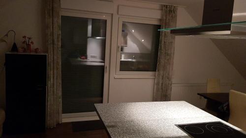 um quarto com uma porta de vidro e uma mesa com uma mesa gmaxwell gmaxwell gmaxwell gmaxwell em Joanna Apartment - MA Rheinau 5 em Mannheim
