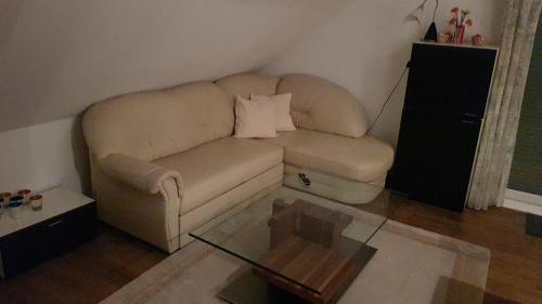sala de estar con sofá y mesa de cristal en Joanna Apartment - MA Rheinau 5, en Mannheim