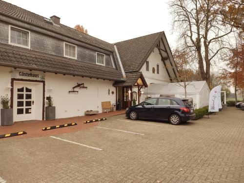 auf einem Parkplatz vor einem Gebäude geparkt in der Unterkunft Hotel Weinhof Groß Mackenstedt in Stuhr