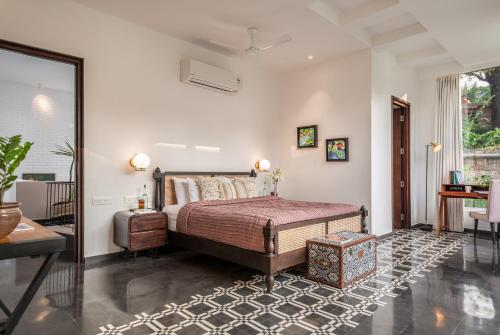 a bedroom with a bed and a large window at La Zamora, 3BHK Villas near Vagator & Anjuna Beach, North Goa with Private Pool, Garden, Terrace & Security in Assagao