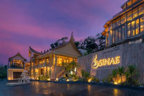 a building with a sign that reads sinemale at night at Sinae Phuket - SHA Extra Plus in Phuket Town