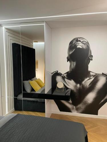 a mirror in a bedroom with a bust of a man at Apartamenty Manhattan in Legnica
