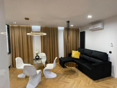 a living room with a black couch and a table at Apartamenty Manhattan in Legnica