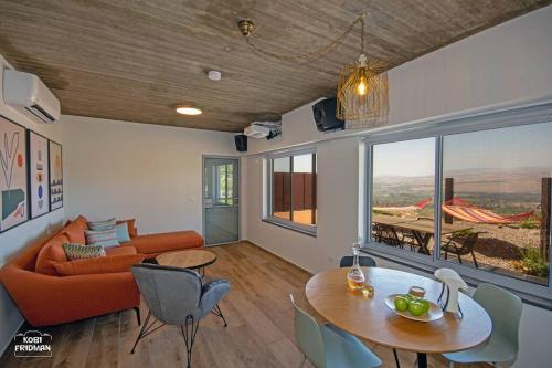een woonkamer met een bank en een tafel bij צימר בוטיק הרימון במעלה גמלא in Ma'ale Gamla