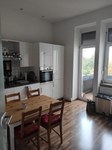 a kitchen with a wooden table and chairs and a dining room at Joanna Apartment - MA Rheinau 4 in Mannheim