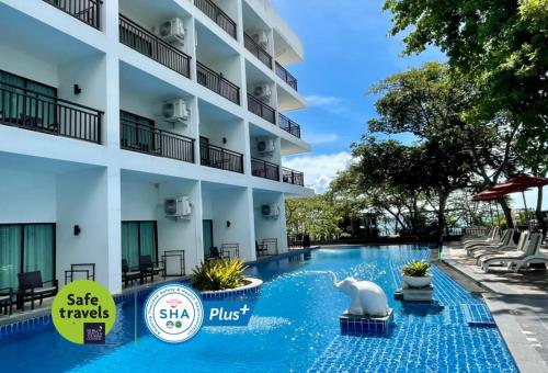 a hotel with a swimming pool in front of a building at Cosy Beach Hotel - SHA Extra Plus in Pattaya South