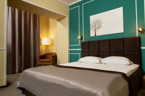 a bedroom with a bed and a green wall at Reikartz Aurora Kryvyi Rih in Kryvyi Rih
