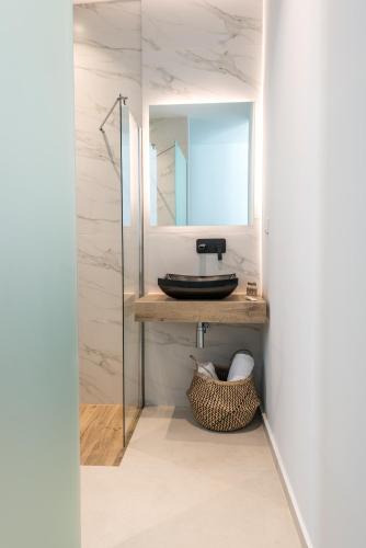 a bathroom with a sink and a mirror at Rivière Residence Paros in Naousa