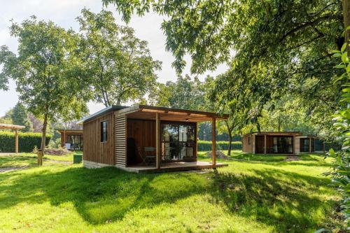 una casita en un campo con árboles en CityKamp Valkenburg - Maastricht, en Valkenburg