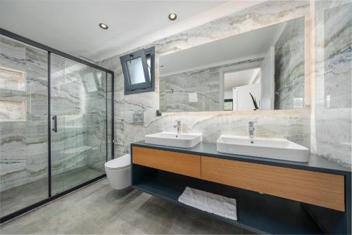 La salle de bains est pourvue de 2 lavabos et d'une douche. dans l'établissement VİLLA ALAVYA ÖLÜDENİZ with heated pool in winter, à Fethiye