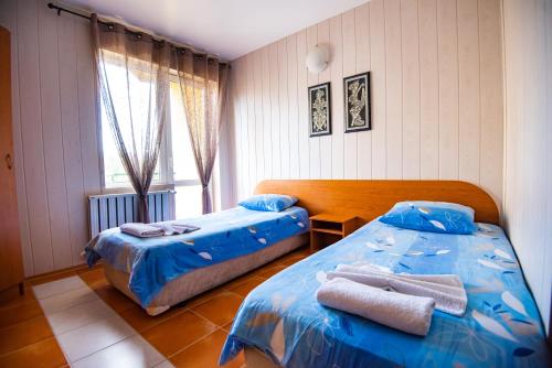 - une chambre avec 2 lits et des serviettes dans l'établissement Семеен Хотел Надежда, à Razlog
