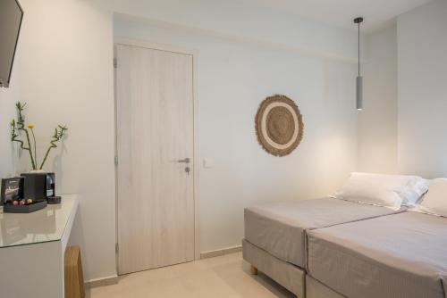 a white bedroom with a bed and a table at Rivière Residence Paros in Naousa