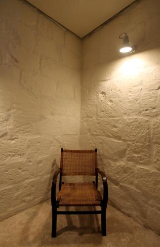 a wooden chair in a room with a white wall at The King George Village Boutique Living in Għargħur