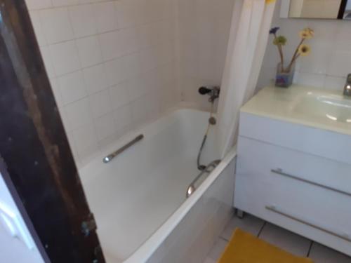 ein Badezimmer mit einer Badewanne und einem Waschbecken in der Unterkunft Studio Climatisé - Piscine-Plage - 1 à 2 personnes in Sainte-Anne
