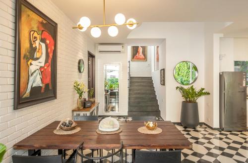 a dining room with a table and a painting on the wall at La Zamora, 3BHK Villas near Vagator & Anjuna Beach, North Goa with Private Pool, Garden, Terrace & Security in Assagao