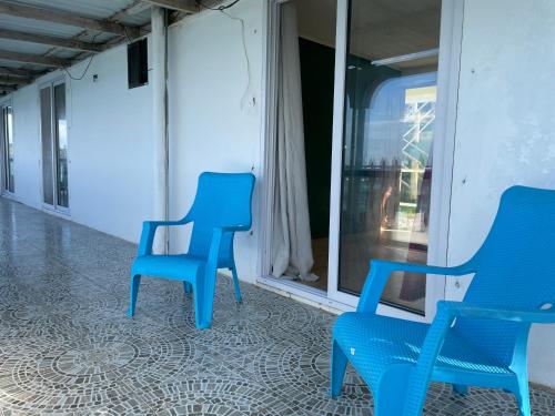 two blue chairs sitting next to a window at The Wave Hostel Corn Island in Corn Island