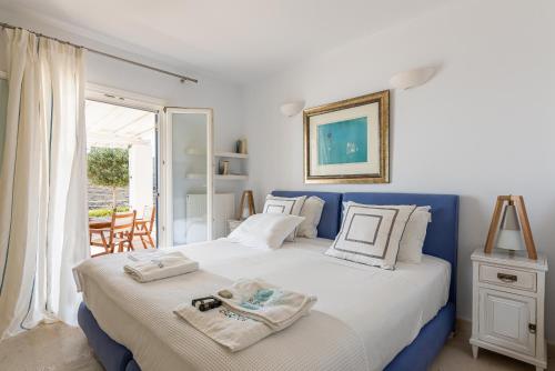 a bedroom with a blue and white bed and a window at BluEros Luxury Villa - Syros Private Pool Gem in Megas Gialos - Nites