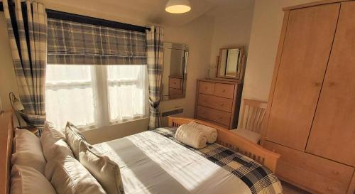 a small bedroom with a bed in front of a window at 127 on Atholl in Pitlochry
