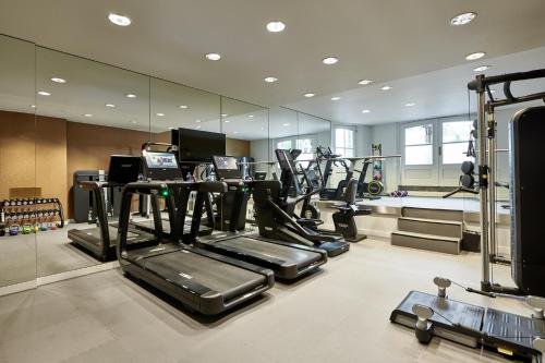 a gym with several tread machines and a mirror at De L’Europe Amsterdam – The Leading Hotels of the World in Amsterdam