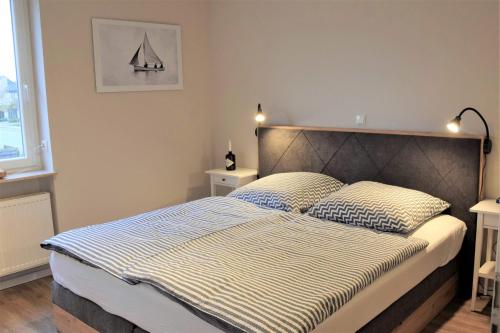um quarto com uma cama grande e 2 almofadas em Ferienwohnung Strandbutze**** em Büsum