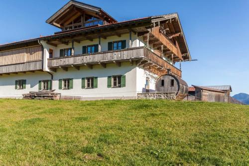 a building on top of a grassy hill at Ferienwohnung Guffertblick in Jachenau