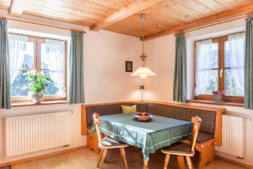a dining room with a table and chairs and windows at Ferienwohnung Karwendelblick in Jachenau
