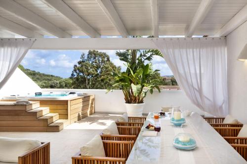 a patio with a table and chairs and a swimming pool at Grand Hotel Cannigione in Cannigione