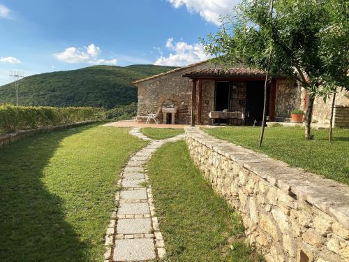 a stone house with a stone wall in front of it at Piedirocca Apartments in Roccantica