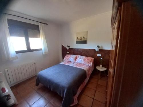 a small bedroom with a bed and a window at Posada de Campillo in Campillo de Altobuey