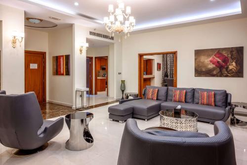 a living room with a blue couch and chairs at Ramada by Wyndham Downtown Dubai in Dubai