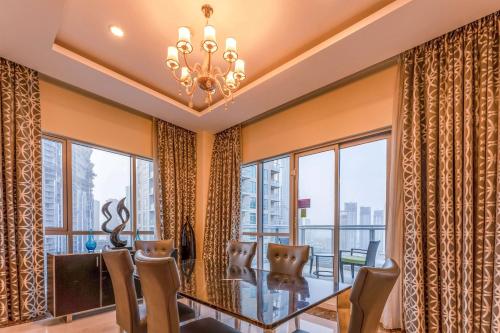 a dining room with a table and chairs and windows at Ramada by Wyndham Downtown Dubai in Dubai