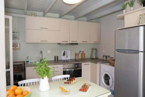 a kitchen with white appliances and a table with food on it at Camara Homes in Andros