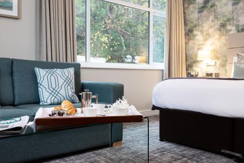 a hotel room with a bed and a couch and a table at Castle Green Hotel In Kendal, BW Premier Collection in Kendal