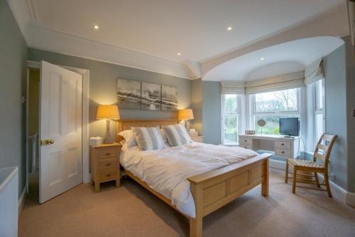 a bedroom with a large bed and a window at Mairannedd in Abersoch