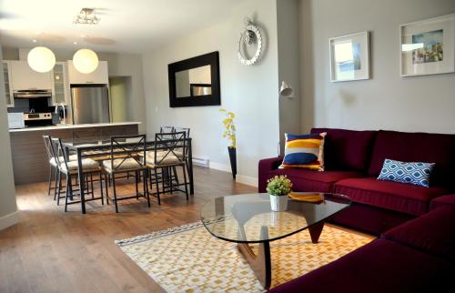 a living room with a red couch and a table at Le Mont-Royal Sky by HomeInMontreal in Montréal