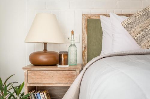a lamp on a night stand next to a bed at La Zamora, 3BHK Villas near Vagator & Anjuna Beach, North Goa with Private Pool, Garden, Terrace & Security in Assagao