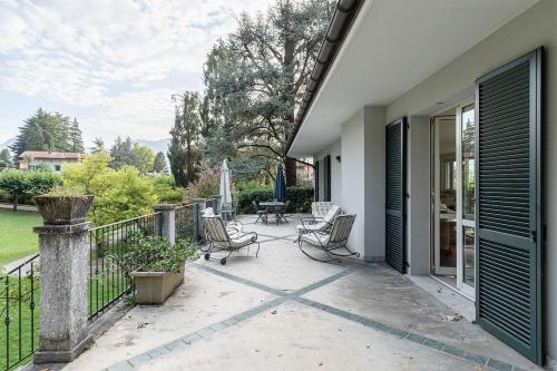a patio with chairs and tables on a balcony at Villa Elisabeth in Lierna