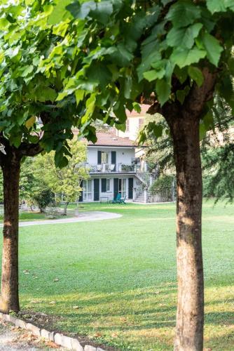 two trees in a field with a house in the background at Villa Elisabeth in Lierna
