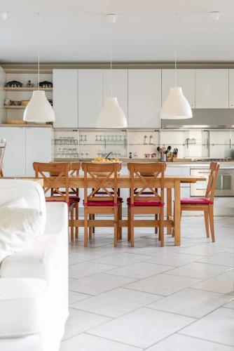 a kitchen with white cabinets and a wooden table and chairs at Villa Elisabeth in Lierna