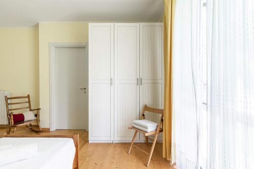 a bedroom with a bed and a chair and a closet at Villa Elisabeth in Lierna