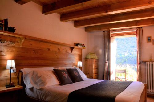 a bedroom with a bed with a wooden wall at La Fattoria di Roven in Gignod
