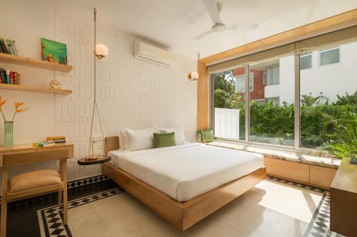 a bedroom with a bed and a window at La Zamora, 3BHK Villas near Vagator & Anjuna Beach, North Goa with Private Pool, Garden, Terrace & Security in Assagao