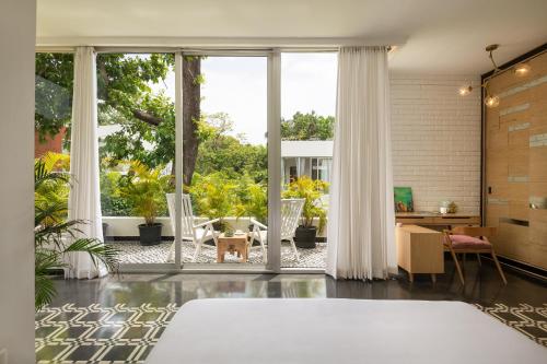 an open living room with a large sliding glass door at La Zamora, 3BHK Villas near Vagator & Anjuna Beach, North Goa with Private Pool, Garden, Terrace & Security in Assagao