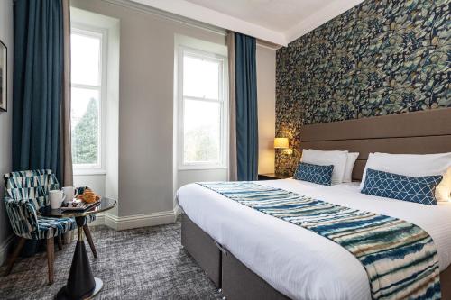 a hotel room with a bed and a chair at Castle Green Hotel In Kendal, BW Premier Collection in Kendal
