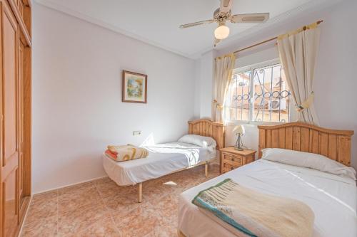 Un dormitorio con dos camas y una ventana. en Casa Roncar, en Torrevieja