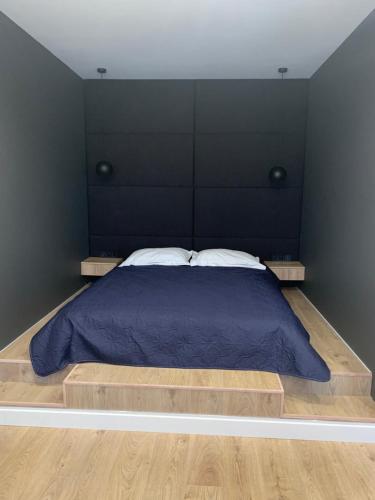 um quarto com uma cama grande e uma cabeceira preta em Apartment near the airport em Boryspil