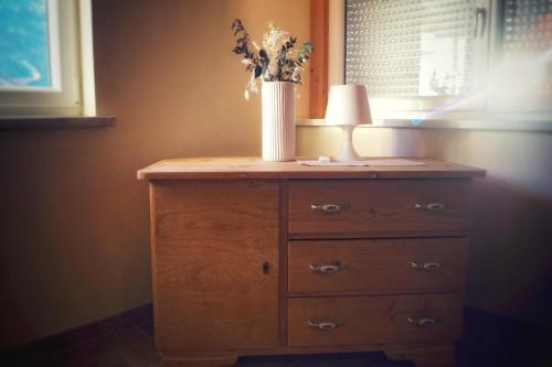 a vase of flowers on a dresser with a lamp at Ferienwohnung Alpbachtal in Radfeld