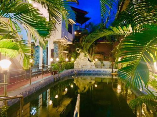 a pool in the middle of a building with palm trees at Swarajdeep Vacations in Port Blair