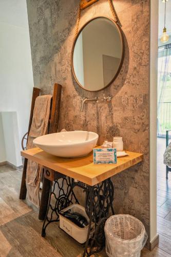 a bathroom with a sink and a mirror on a table at Al Tirabusòn Country House in Nizza Monferrato